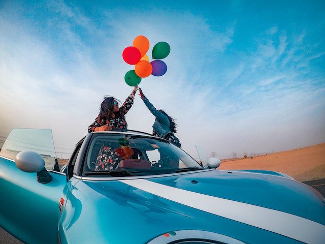 photo of couple celebrating in a convertible auto transport rates